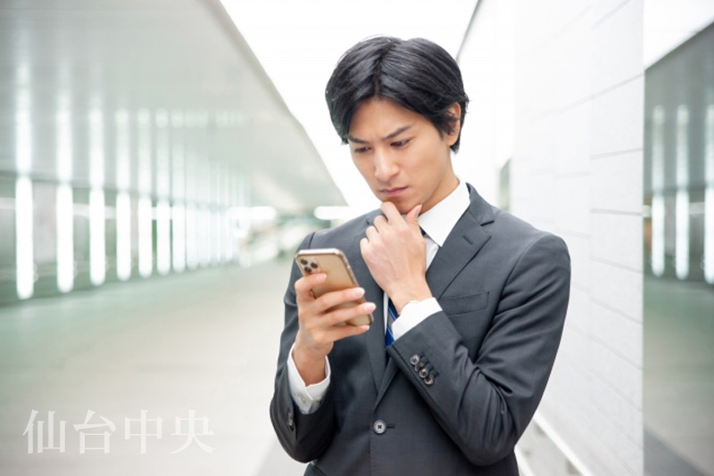 仮性包茎についてスマホで検索する男性